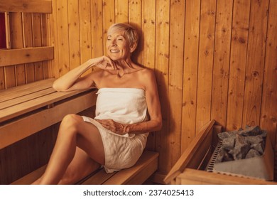 Mature woman is relaxing in sauna. Healthy lifestyle for elderly people. Spa concept.
