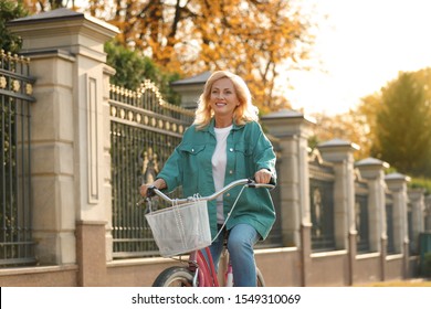 Mature Woman Riding Bicycle Outdoors. Active Lifestyle