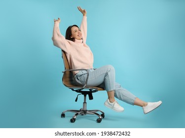 Mature Woman Riding In Comfortable Office Chair On Turquoise Background