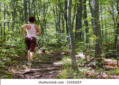 Mature Woman Running In Forest.