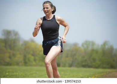 Mature Woman Running Outdoors In The Park