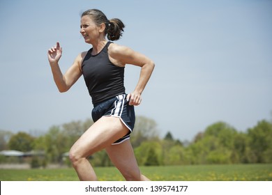 Mature Woman Running Outdoors In The Park