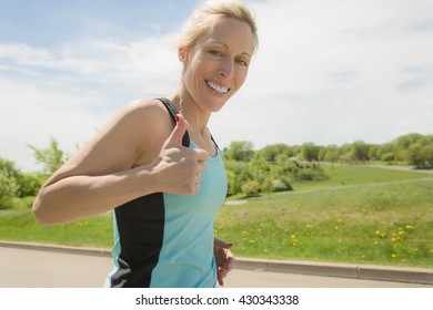 A Mature Woman Running Outdoors In The Park