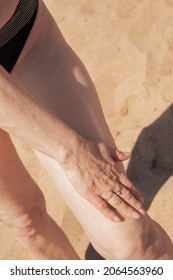 Mature Woman With Sagging Skin Smears Her Legs With Sunscreen. Protecting The Skin From The Bright Sun.