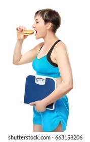 Mature Woman With Scales And Hamburger On White Background. Weight Loss Concept