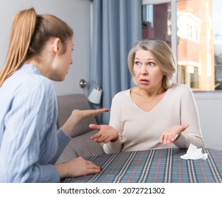 Mature Woman Scolding Her Upset Adult Daughter At Home Interior