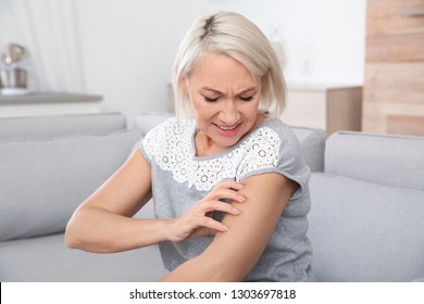 Mature Woman Scratching Arm At Home. Annoying Itch