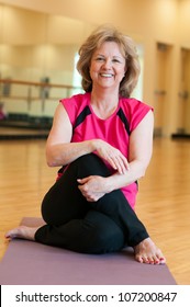 Mature Woman In A Seated Twist Yoga Pose.