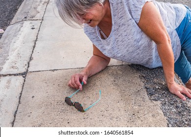 Mature Woman Or Senior Walking In A Building Zone And Falling In A Big Hole With Her Leg Inside It - Needing Help On The Ground With Ache