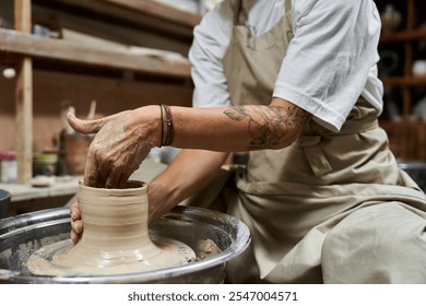 A mature woman shapes clay on a pottery wheel in her inviting workshop, showcasing her craft. - Powered by Shutterstock