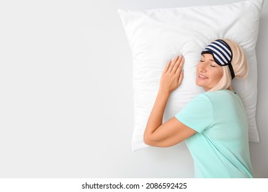 Mature Woman In Sleep Mask On Light Background