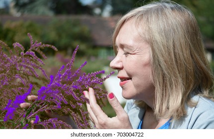 Mature Woman Smelling Flowers