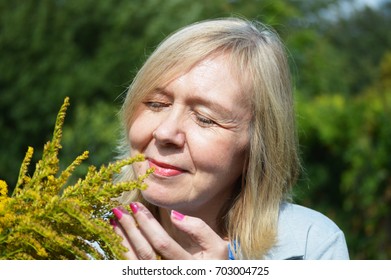 Mature Woman Smelling Flowers
