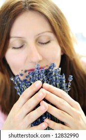 Mature Woman Smelling Lavender Flowers - Focus On Hands