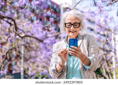 mature woman smiling happy typing on mobile phone - Powered by Shutterstock