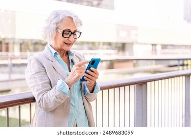 mature woman smiling happy while typing on phone - Powered by Shutterstock