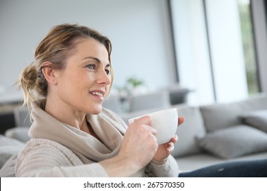 Mature Woman In Sofa Drinking Hot Coffee