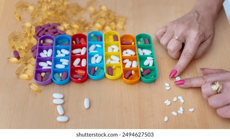 Mature woman splits a white pill in half with her fingers to organize the taking of medication - Powered by Shutterstock