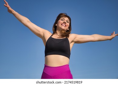 Mature Woman In Sportswear Jumping In The Air Happy In An Outdoor Park. Fitness Concept, Maturity, Relax, Happiness, Jumping.