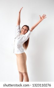 Mature Woman Standing Isolated On White Wall Hands Up Free Looking Camera Smiling Happy Side View Full Body Shot