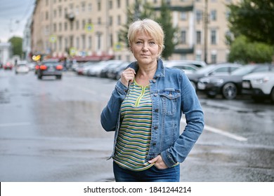 Mature Woman Stands On Street In City.