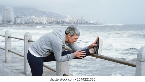 Mature woman, stretching legs and fitness at ocean with peace, flexibility or running preparation. Retired athlete, warm up or muscle tension relief at seaside for exercise, wellness or care in Italy - Powered by Shutterstock