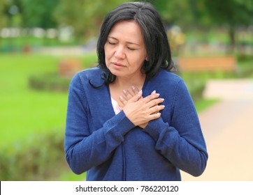 Mature Woman Suffering From Heart Attack Outdoors