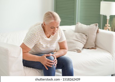 Mature Woman Suffering From Pain In Knee At Home