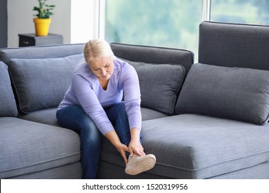 Mature Woman Suffering From Pain In Leg At Home