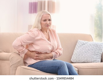 Mature Woman Suffering From Stomach Ache At Home