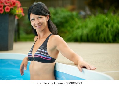 Mature Woman Swimming In A Blue Water Pool