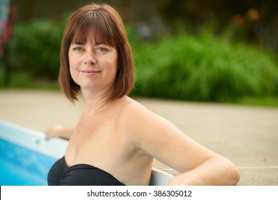 Mature Woman Swimming In A Blue Water Pool