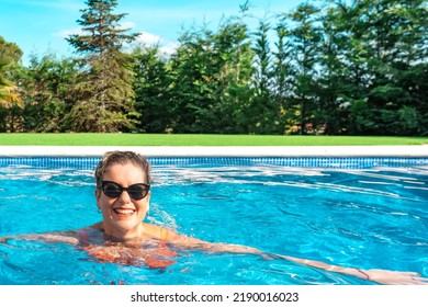 Mature Woman Swimming Happily In The Pool At Home On Summer Holidays. Business Woman Swimming In Her Free Time. Holiday And Travel Concept.