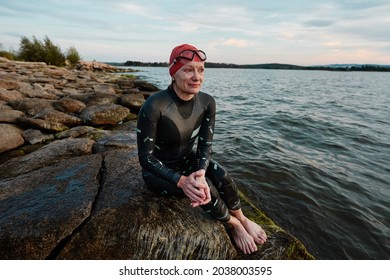 Mature Woman In Swimwear Sitting On The Rock After Swimming In The Lake