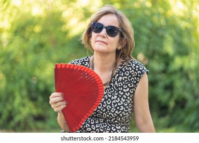 Mature Woman With Symptoms Of Menopause With Strong Hot Flashes And Fanning.