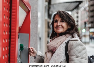 Mature Woman Taking Money From An ATM On The Street