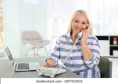 Mature Woman Talking On Phone At Workplace