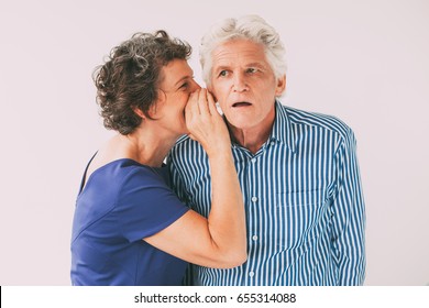 Mature woman telling secret to husband