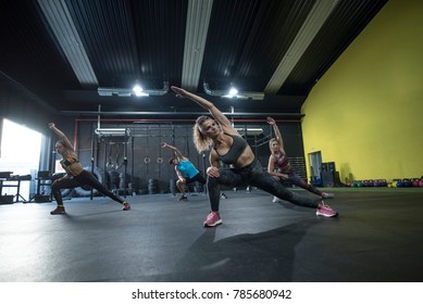 Mature Woman Training Crossfit Class And Strenght Flexibility Exercises At Gym Floor 