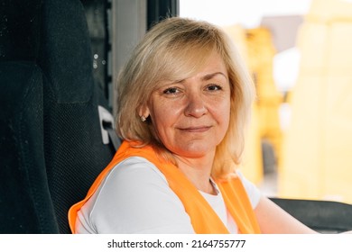 Mature Woman Truck Driver Steering Wheel Inside Lorry Cabin. Happy Middle Age Female Trucker Portrait 