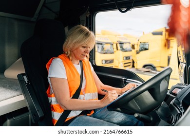 Mature Woman Truck Driver Steering Wheel Inside Lorry Cabin. Happy Middle Age Female Trucker Portrait 