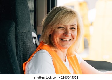 Mature Woman Truck Driver Steering Wheel Inside Lorry Cabin. Happy Middle Age Female Trucker Portrait 