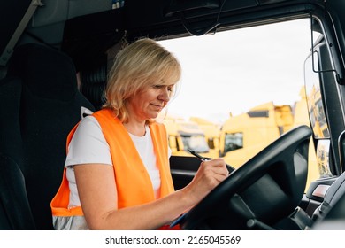 Mature Woman Truck Driver Steering Wheel Inside Lorry Cabin. Happy Middle Age Female Trucker Portrait 