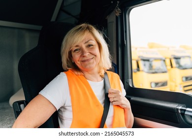 Mature Woman Truck Driver Steering Wheel Inside Lorry Cabin. Happy Middle Age Female Trucker Portrait 