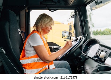 Mature Woman Truck Driver Steering Wheel Inside Lorry Cabin. Happy Middle Age Female Trucker Portrait 