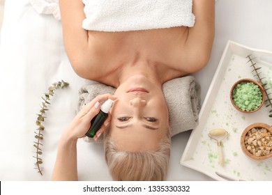 Mature Woman Undergoing Treatment With Face Serum In Beauty Salon