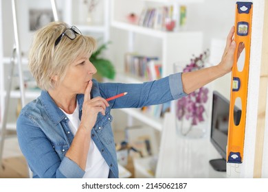 Mature Woman Using Spirit Level In The Home