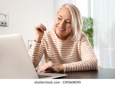 Mature Woman Using Video Chat On Laptop At Home