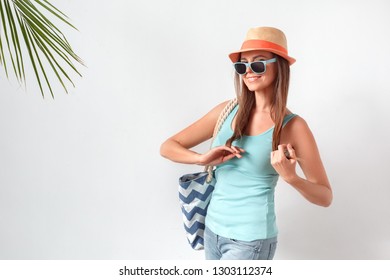 Mature Woman Wearing Hat And Sunglasses Standing Studio Isolated On White Wall Carrying Beach Bag Posing To Camera Smiling Playful