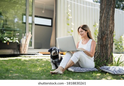 Mature Woman Working In Home Office Outdoors In Garden, Using Laptop.